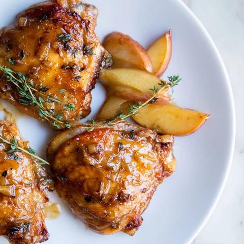 Golden and glazed Sticky Maple Apple Chicken, with glistening skin and tender apple wedges alongside.