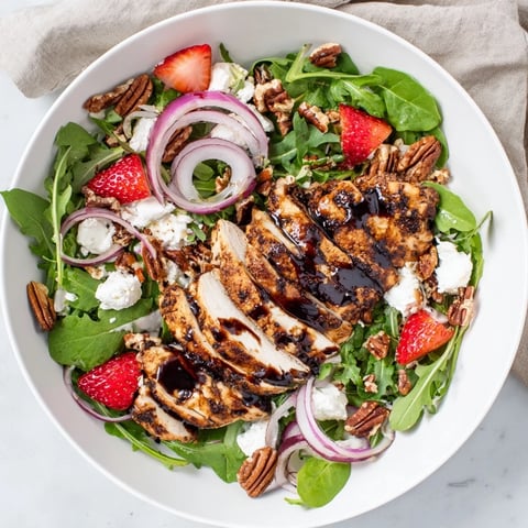 Juicy Honey Balsamic Chicken Salad with fresh strawberries and creamy goat cheese arranged artfully.