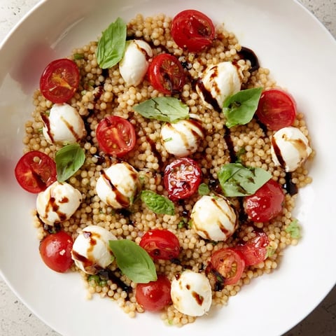 Vibrant Caprese Couscous Salad, a colorful medley showcasing juicy tomatoes and creamy mozzarella.