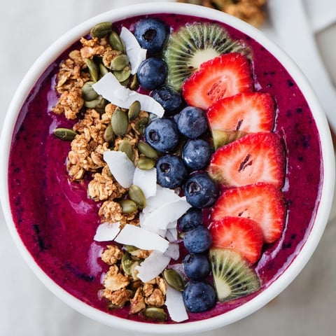 Creamy red Beet and Berry Smoothie Bowl topped with crunchy granola and sliced kiwi for a vibrant, nutrient-packed breakfast.