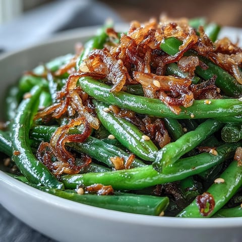 Crispy fried onions top tender sesame garlic green beans in this savory Asian-inspired side dish.  