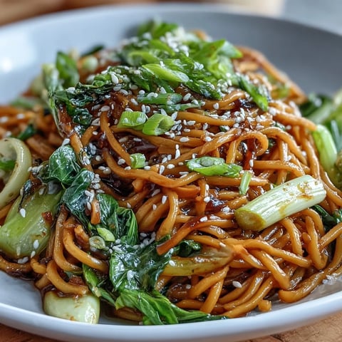 Vibrant Asian ginger scallion noodles tossed with sautéed greens, featuring silky noodles in a savory ginger sauce for a fresh, aromatic meal.