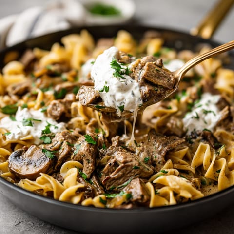 A bowl of pasta with meat and sauce.