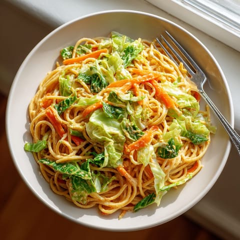 A plate of Thai Peanut Noodles with Shredded Cabbage.