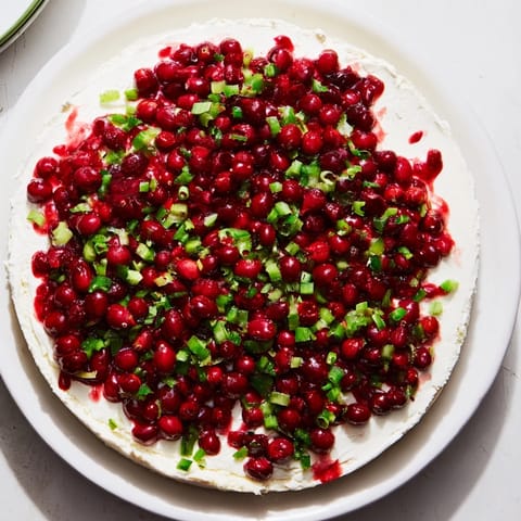 A close-up of a generously topped Spiced Cranberry Jalapeño Cream Cheese Dip perfect for entertaining.