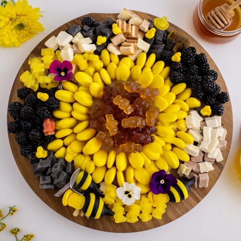 This Bumblebee Candy Board presents an inviting array of yellow, black, and sweet treats.