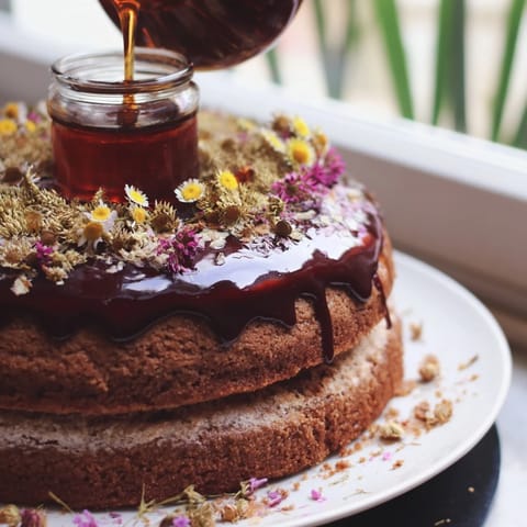 A multi-layered The Honey-Drip dessert with a central honey pot and toasted almond garnish.