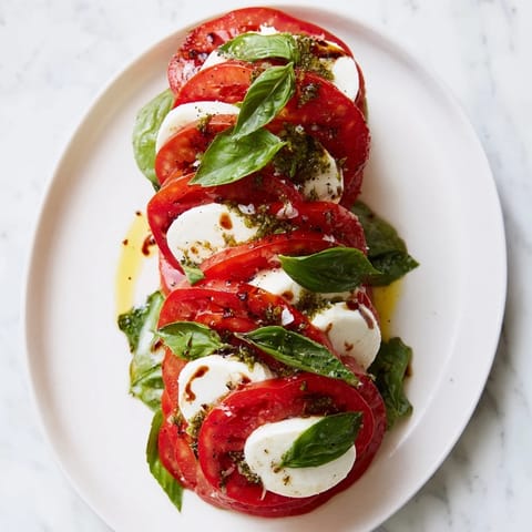 Beautifully stacked Tuscan Pillar, a vegetarian appetizer of tomatoes, mozzarella, and fresh basil leaves.