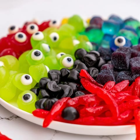 A visually stunning Poison Apple Candy Platter, brimming with apple candies, licorice bits, and spooky eyeballs.