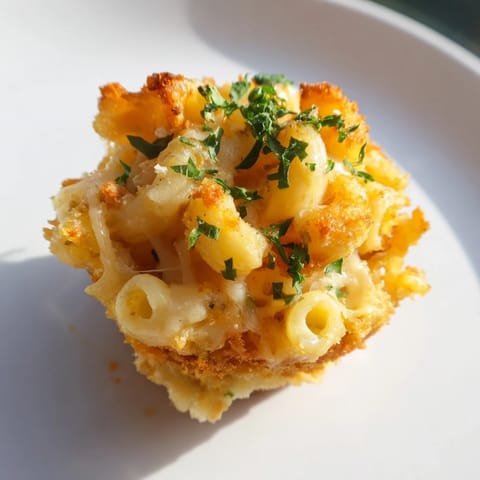 A close-up of baked Tinis Mac and Cheese, showcasing the bubbly, cheesy, and crunchy panko topping.