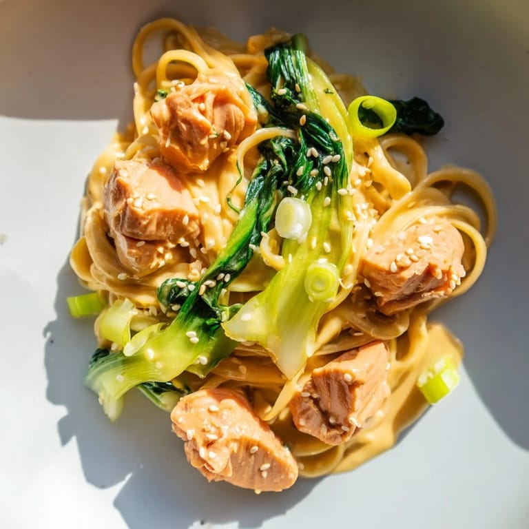 Perfectly cooked miso butter salmon pasta with vibrant green bok choy, ready for a flavorful bite.