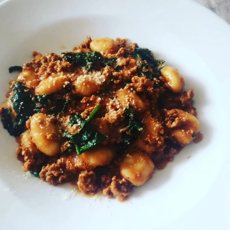 Hearty Italian-inspired sausage gnocchi tossed with wilted kale and diced tomatoes, served hot and steaming from the skillet.