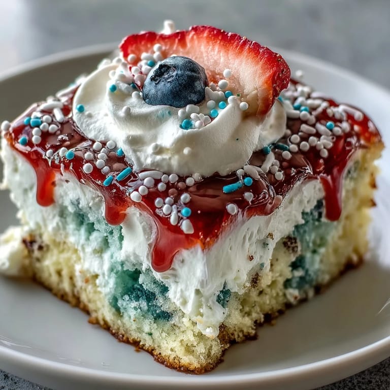 Luscious Memorial Day Poke Cake, a patriotic dessert crowned with fluffy whipped topping.