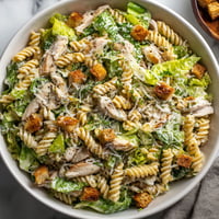 A bowl of chicken Caesar pasta salad.