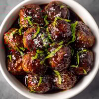 A bowl of meatballs with sauce.