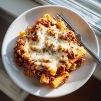 A plate of pasta with meat and cheese.
