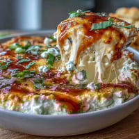 Creamy cottage cheese buffalo chicken dip with shredded chicken, spicy sauce, and melty cheeses, served hot and bubbling in a baking dish.