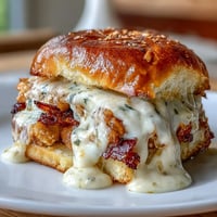 Gourmet Kentucky Derby Hot Brown sliders on toasted brioche buns, layered with roasted turkey, bacon, and creamy Mornay sauce.  