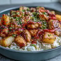 A colorful one-pan Pineapple Chicken and Rice Skillet with bell peppers, tender chicken, and sweet pineapple in a savory sauce.